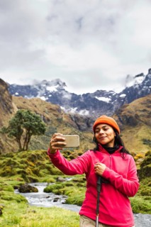 Ecuadorian woman takes a selfie against the backdrop of El Altar volcano, showcasing stunning