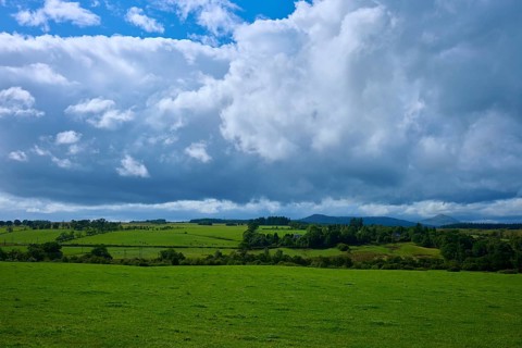 Wide green fields and hills under a cloudy sky, Scotland, United Kingdom, Great Britain