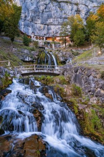 A waterfall flowing over rocks with a bridge in the foreground, St. Beatus Hö Lake Brienz,