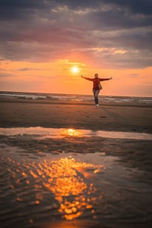 Tourist in red at sunset on the beach, Zandvoort, Netherlands