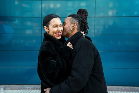 A happy multicultural couple enjoys a tender moment outdoors, embracing love and diversity. The