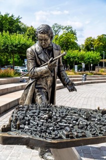 Silver figure explorer traveling by Ekaterina Kovalenko on Castle Square with bronze model of the