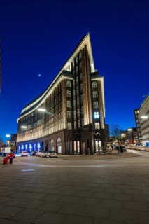 Modern, narrowly tapered building with lighting on the street corner, Hamburg, Germany