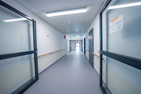 Bright corridor with double glass doors, modern interior in blue and white colors, new Calw
