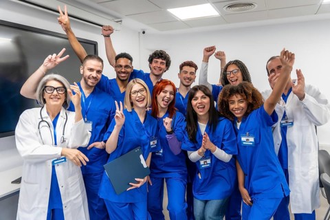 Diverse group of healthcare professionals, including doctors, nurses, and students, expressing joy