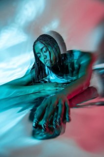 A futuristic African young woman is immersed in the vibrant metaverse, represented with dynamic