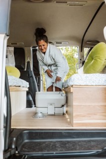 A woman enjoying her van life routine in New Zealand during autumn. She engages in everyday