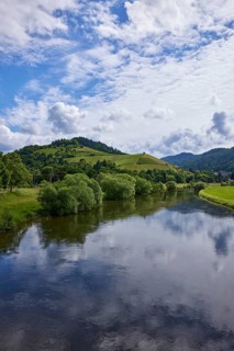 River Kinzig with landscape and blue sky with cumulus clouds in light backlight near Gengenbach,