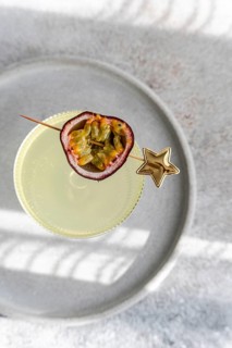 Top view of an elegant cocktail made with tonic, gin, and passion fruit juice, garnished with a