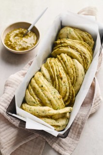 Ready to bake, homemade savoury babka plaited bread loaf flavoured with cheese and pesto, in the