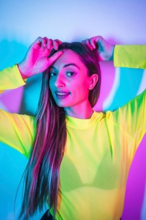Party lifestyle in a nightclub with pink blue neon lights, portrait of a young blonde Caucasian