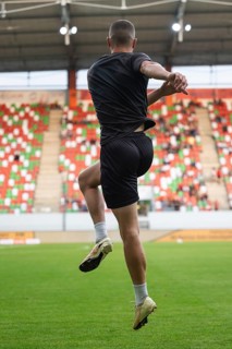 Silhouette of a football player warming up at the stadium before the match