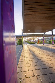 Schoolyard with modern architecture and sunshine casting long shadows, Schlehengäuschule,