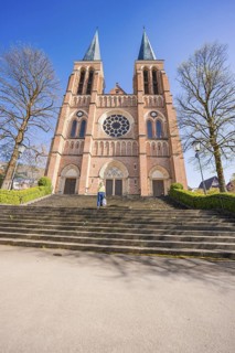 Front view of a large brick church with double towers and stairs, Sacred Heart, Bregenz, Austria
