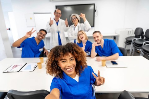 Diverse group of doctors and nurses wearing scrubs and lab coats, celebrating success and teamwork