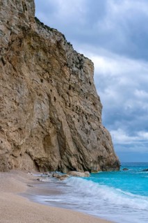 Porto Katsiki beach in Lefkada, Greece, features striking turquoise waters meeting rugged cliffs.
