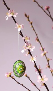 Blooming branches of a peach tree in a vase decorated with Easter egg, spring, Germany