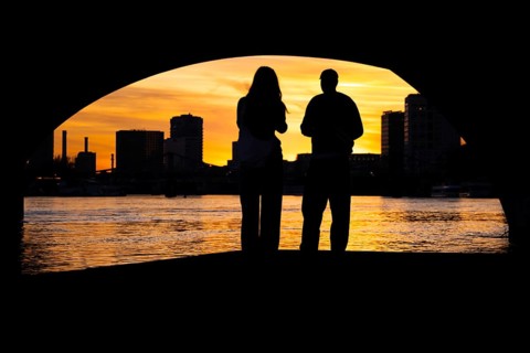 Two people watching the sunset from the banks of the Main, Frankfurt am Main, Hesse, Germany