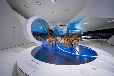 Futuristic depiction of a blue horse-drawn carriage in exhibition, Porsche Museum, Stuttgart,