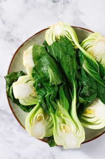 Boiled bok choy, cut on a plate, top view, no people