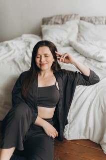 A woman in a cozy living space, dressed in a comfortable outfit, enjoying a peaceful moment. Her