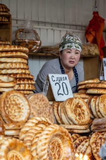 Woman selling bread at a market stall at Osh Bazaar, Bishkek, Kyrgyzstan