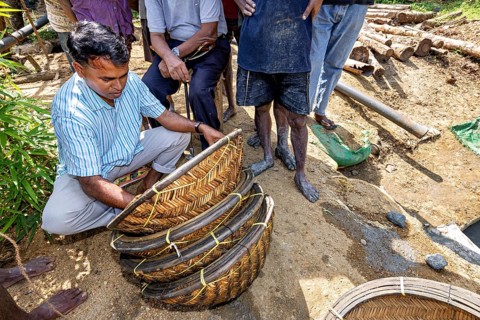 A man works with a basket while others watch, the sapphire and gemstone mines at Ratnapura in Sri