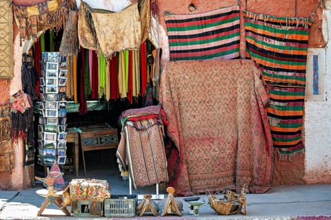 A colourful market stall with oriental-style carpets and textiles, fabric and souvenir shop in