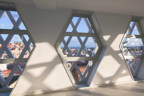 Sunlight streams through hexagonal windows, creating intricate geometric shadows on a modern