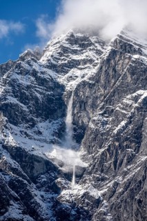 Waterfall of snow on a rock face, Watzmann east face in autumn with snow, Berchtesgaden National