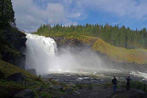 Waterfall with sparkling fog in a wooded landscape, visitors in the foreground, Tännforsen,