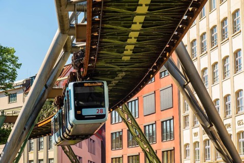 A suspension railway runs between old industrial buildings near the Kluse stop, Wuppertal, Germany