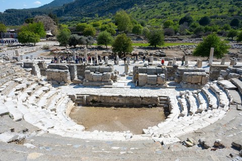 Large ancient theatre with circular rows of seats and green landscape in the background, theatre,
