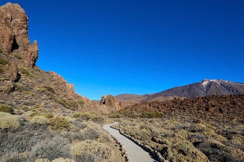 Roques de Garcia, a path that snakes through vegetation with the Teide volcano in the distance,