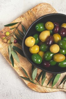 A mixture of olives, varieties of chalkidiki, Verdi giganti and Kalamata, in a bowl, top view, no