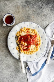 A delicious serving of chifferi rigati pasta topped with rich tomato sauce and grated cheese on a