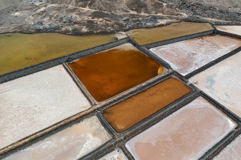 An aerial shot capturing the striking colors and geometric beauty of salt pans at Los Salares de
