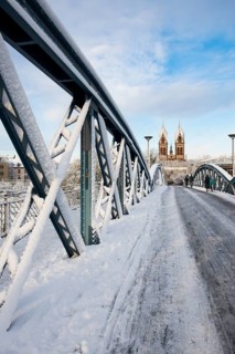 Bridge with snow and ice and cyclists, Blue Bridge and Stühlinger Church, Freiburg im Breisgau,