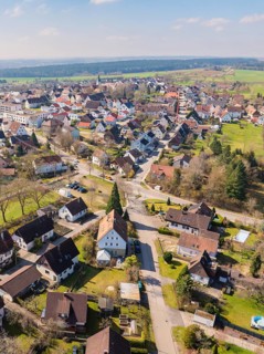 Aerial view of a village with densely built-up houses, streets and surrounding rural landscape