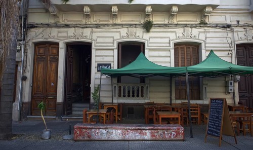 Small street café in front of an old building with wooden doors and windows, Montevideo, Uruguay,
