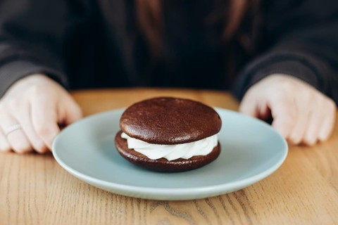 A delectable whoopie pie with a rich chocolate exterior and creamy filling, placed on a ceramic
