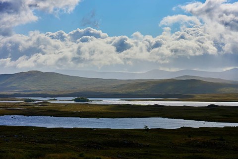 Wide lake landscape under cloudy sky with rolling hills, Rannoch Moor, Bridge of Orchy, Scotland,
