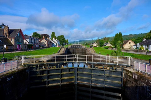A lock between traditional buildings under a blue sky, Caledonian Canal, Fort Augustus, Loch Ness,