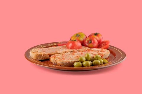 Typical catalan breakfast, pa amb tomaquet with sobrassada, served with olives and tomatoes on a