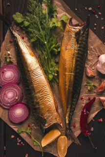Smoked mackerel, top view, with spices, on a wooden table, no people, selective focus