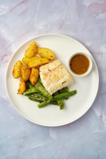 Overhead view of a plate with golden roasted potatoes and vibrant green beans accompanied by a