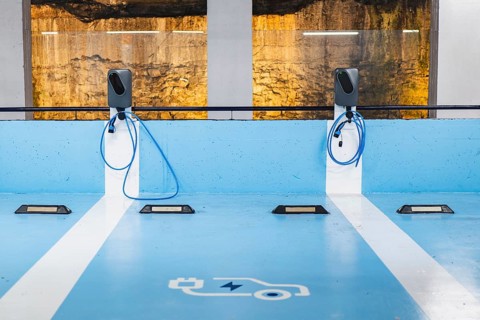Two electric vehicle charging units installed in a designated blue parking area, complete with