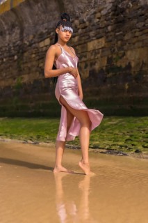 Dominican ethnic girl with braids with a beautiful pink dress. Fashionable posing enjoying summer