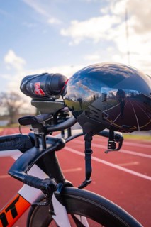 Black bicycle helmet with reflection and camera, parked on a racetrack, triathlon bicycle, Calw,