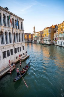 View of the Grand Canal with gondoliers at sunset, picturesque evening mood with palazzos on the